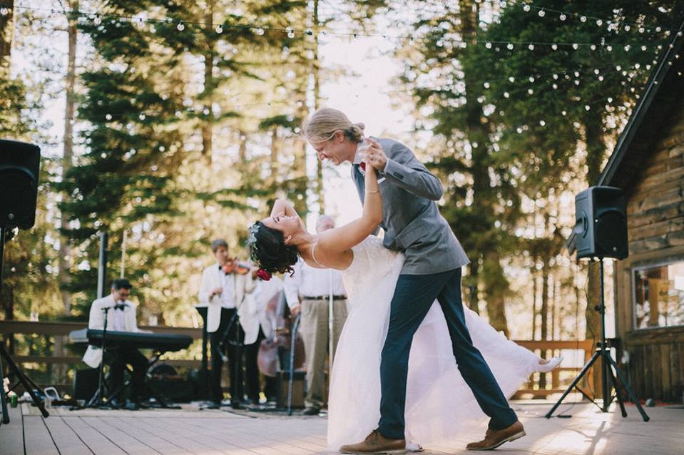 Wedding couple dancing mid-dip with band playing in background.